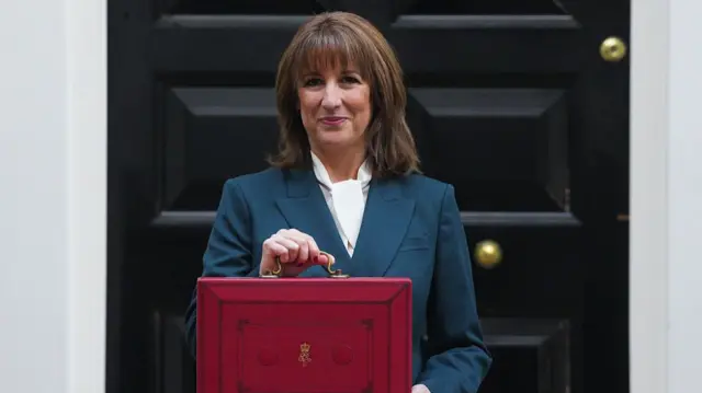 Rachel Reeves stands outside No 11 Downing Street holding the iconic red briefcase.