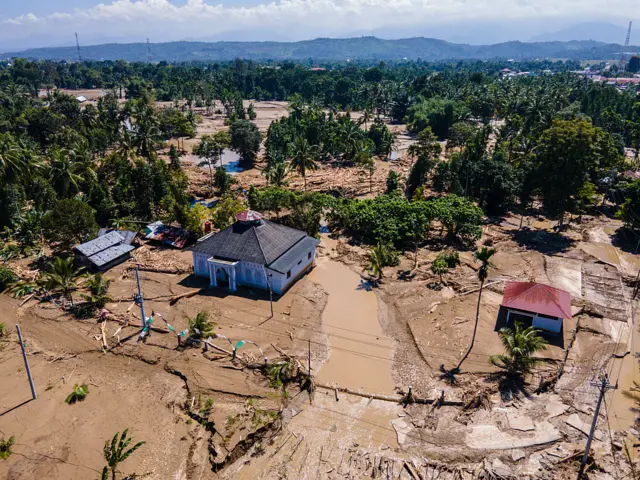 This aerial picture shows a mosque standing amid mud in a flood affected area amid flash floods in Meureudu, Aceh province on 30 November 2025.