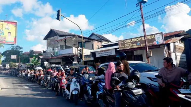 A line of motorcycles and cars