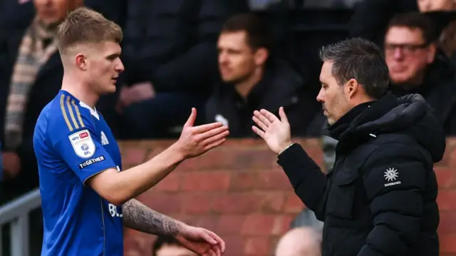 Marti Cifuentes shakes hands with Jordan James during Derby win