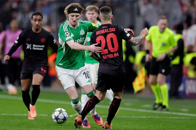 Anthony Gordon of Newcastle, Alejandro Grimaldo of Bayer 04 Leverkusen