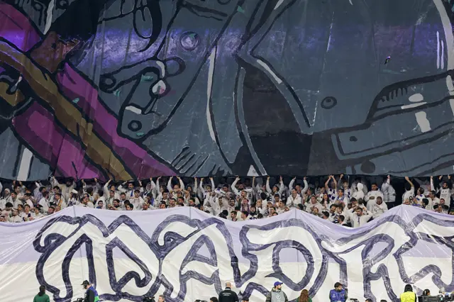 Real Madrid supporters hold up banners