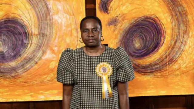 An artist stands in front of her Turner Prize-winning work.