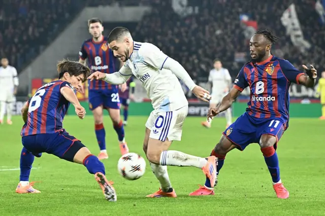 Aston Villa's Argentine midfielder #10 Emiliano Buendia (C) fights for the ball with Basel's Japanese defender #06 Keigo Tsunemoto (L) and Basel's Ivorian forward #11 Benie Traore (R) during the UEFA Europa League, league phase, football match between FC Basel and Aston Villa at the St Jakob-Park stadium, in Basel, on December 11, 2025.