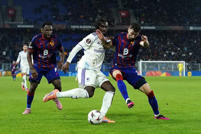 Evann Guessand of Aston Villa is challenged by Dominik Schmid of FC Basel 1893 during the UEFA Europa League 2025/26 League Phase MD6 match between FC Basel 1893 and Aston Villa FC at St. Jakob-Park on December 11, 2025 in Basel, Switzerland.