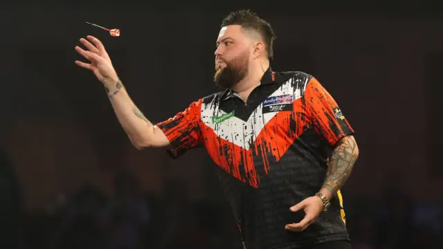 Michael Smith throws a dart