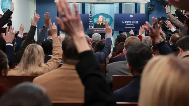 Hands are raised as White House press secretary Karoline Leavitt holds a press briefing at the White House