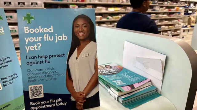 A sign with 'booked your flu jab yet?' written on it, in a pharmacy