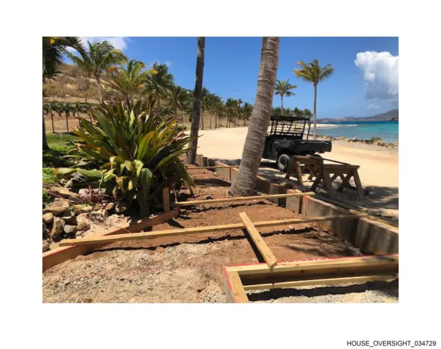 A beach with construction going on and palm trees