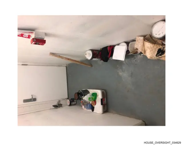 What look like cleaning supplies lie on the floor inside the Epstein estate