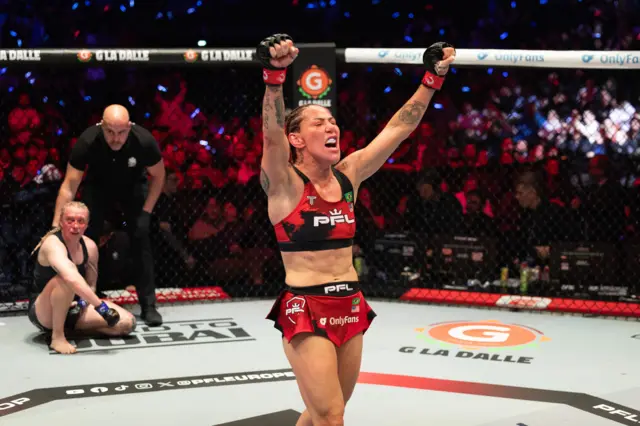 Cris Cyborg celebrates with her arms raised