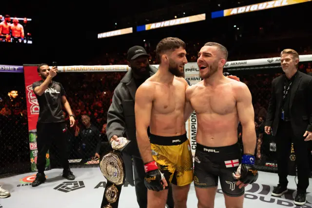 Adiguzel and Dean Garnett have their arms around each other