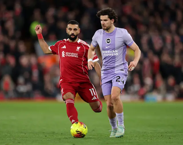 Ferdi Kadioglu of Brighton & Hove Albion runs with the ball whilst under pressure from Mohamed Salah