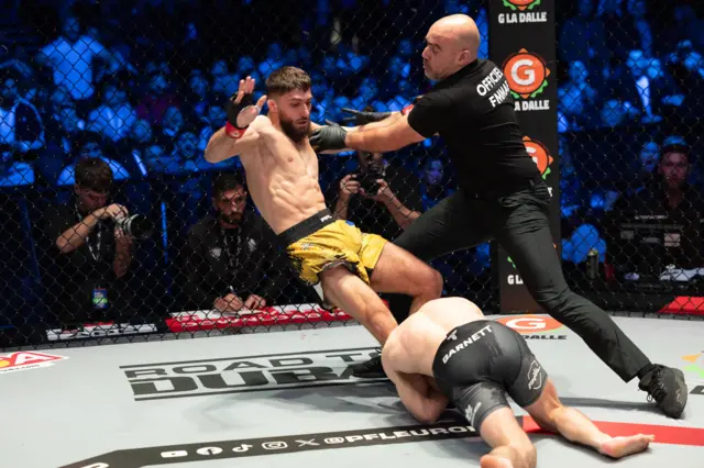 The referee pushes Baris Adiguzel away from Dean Garnett