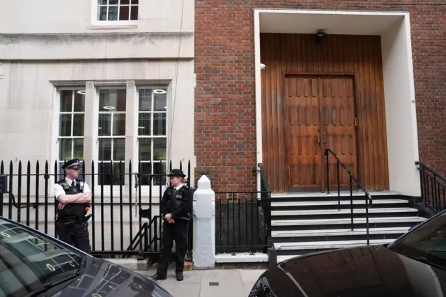 Two Met Police officers in uniform patrol outside the London synagogue in Mayfair