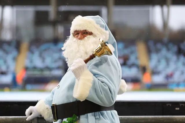 A fan dressed in Santa costume poses for a photo