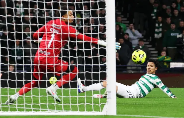 Reo Hatate watches the ball fly into the bottom corner of the net