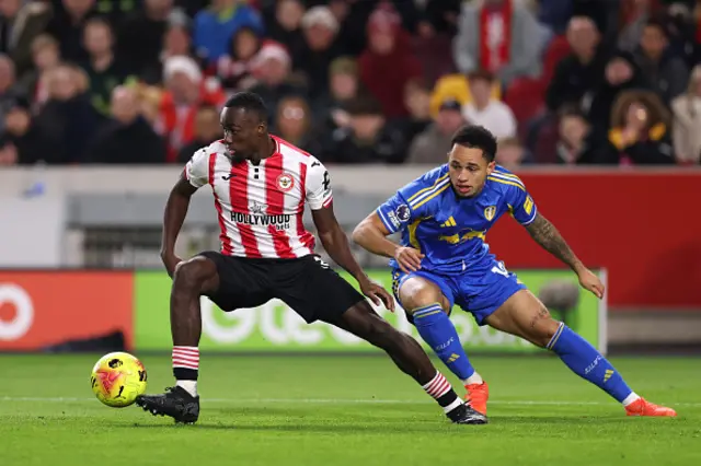 Michael Kayode of Brentford controls the ball whilst under pressure from Noah Okafor