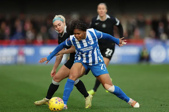 Madison Haley of Brighton & Hove Albion battles for possession with Ellie Carpenter of Chelsea during the Barclays Women's Super League match between Brighton & Hove Albion and Chelsea FC at Broadfield Stadium on December 14, 2025 in Crawley, England.