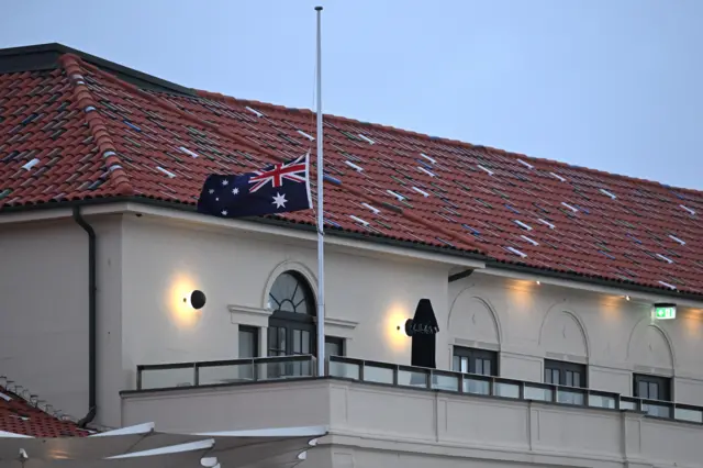 An Australian flag flies at half mast on Bondi Pavilion