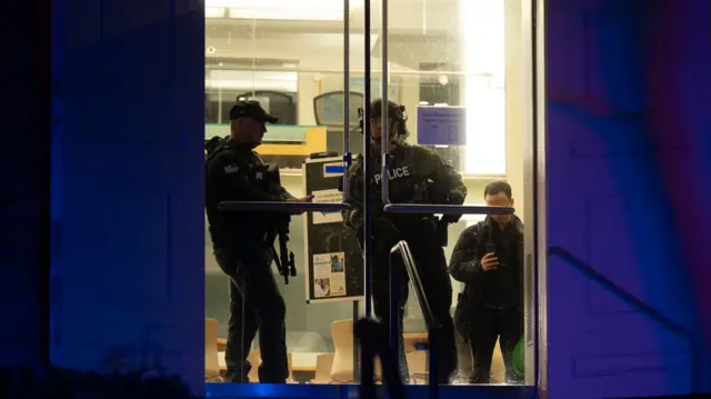 Police inside Brown University, escorting students away from the campus