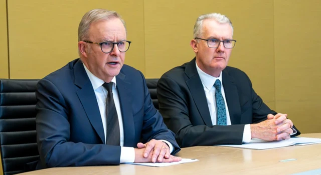 Two men - one of whom is Australian PM Anthony Albanese - looking out of frame to the right wearing suits, black glassed and grey hair