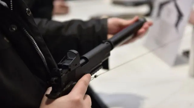 A stock photo of someone holding a gun in a shop