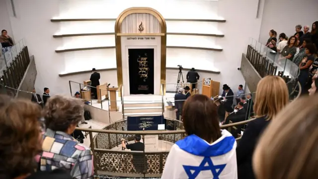 Backs of mourners pictured at a vigil at the Chabad of Bondi in Sydney, Australia