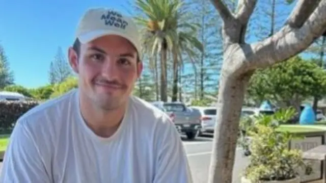 Constable Scott Dyson is pictured wearing a white t shirt with a hat saying "we mean well".