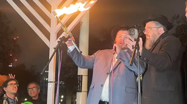 Rabbi Schlanger's nephew - Rabbi Shimshon Gansbourg lighting the Chanukah candles.