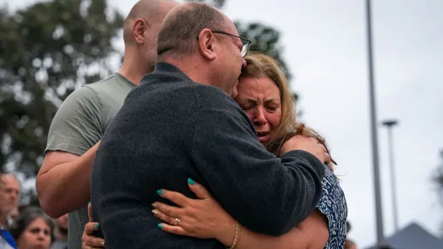 A man and a woman, described by Getty as the parents of Matilda, embrace each other, with anguished faces
