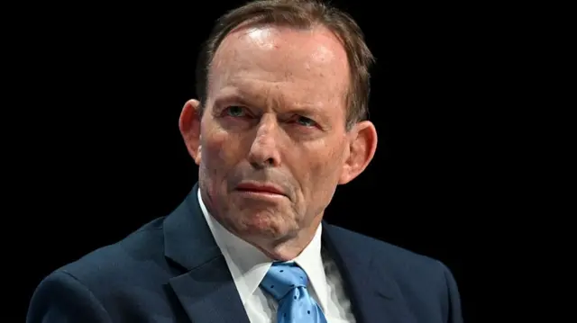 Tony Abbott, Australia's former prime minister, pictured at the Conservative Party conference in Manchester, UK, on Tuesday, Oct. 7, 2025. He is wearing a navy suit, blue tie and has short brown hair