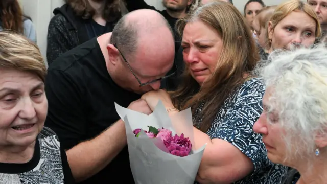 Parents of Matilda hug with flowers