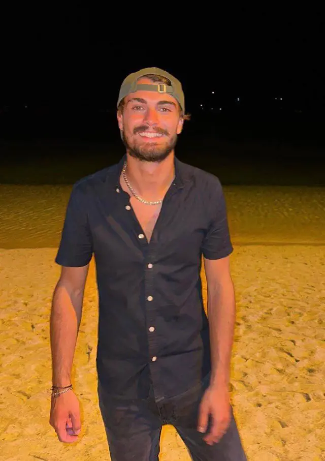 Man standing on beach smiling at camera