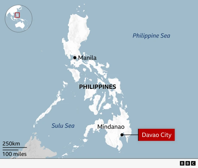 Map of the Philippines highlighting several locations. The capital, Manila, is marked on the northern island of Luzon. The southern island of Mindanao is labelled, with Davao City highlighted in a red box on its southeastern coast. The Philippine Sea to the east and the Sulu Sea to the southwest are also labelled. An inset globe indicates the country’s position in Southeast Asia.