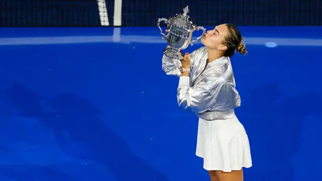 Aryna Sabalenka kisses her trophy at the US Open