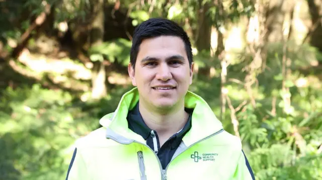 Jesse Lenn in a fluoro yellow jacket with the words 'community health support' on the left breast.