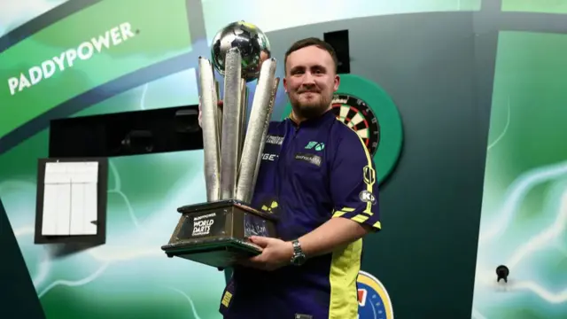 Luke Littler with the World Championship trophy