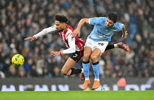 Brentford's Kevin Schade in action with Manchester City's Abdukodir Khusanov