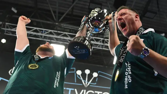 Daryl Gurney lifts the World Cup trophy with Josh Rock