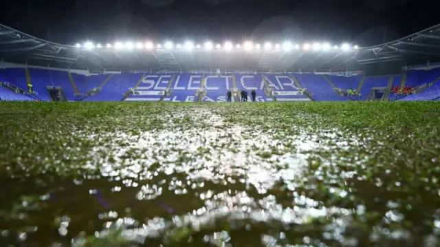 The view across the pitch at the Select Car Leasing Stadium with a very muddy patch in the foreground of the image