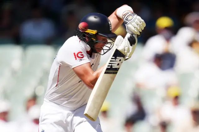 England's Jamie Smith gets hit on the head off the bowling of Australia's Pat Cummins