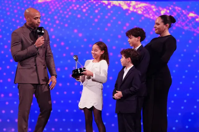 Thierry Henry receives the BBC Sports Personality Lifetime Achievement Award from his children during the 2025 BBC Sports Personality of the Year Awards