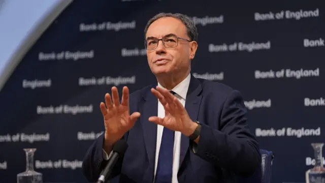 Andrew Bailey sits at a table in a blue jacket