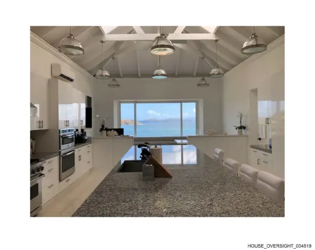 A large, glamourous kitchen with large windows looking out on the sea front