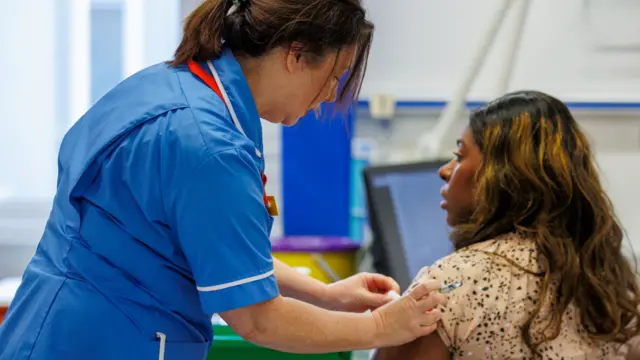 Woman receives annual flu vaccine from nurse