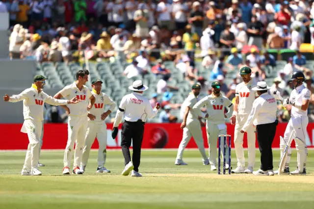 Players look on during a review