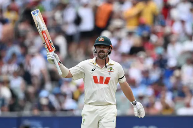 Travis Head celebrates his half-century