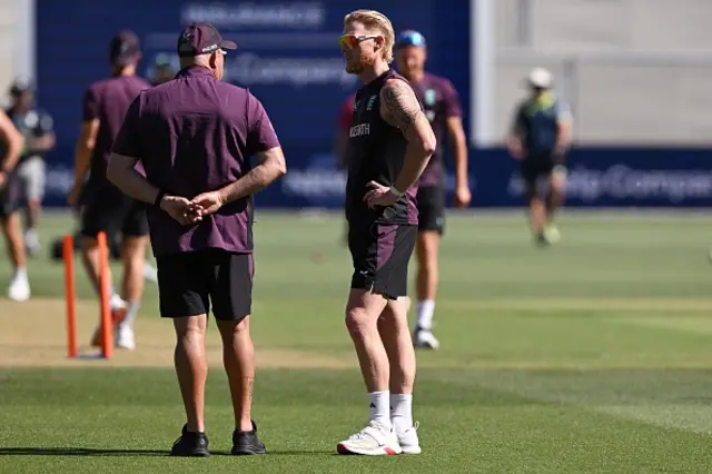 England captain Ben Stokes (C) chats with the coaching staff