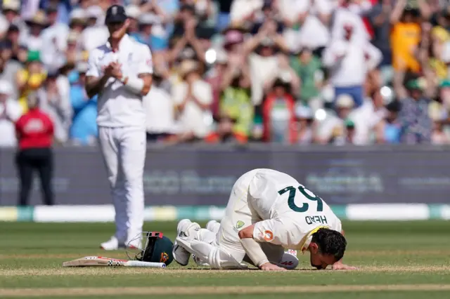 Travis Head kisses the Adelaide pitch after reaching his century